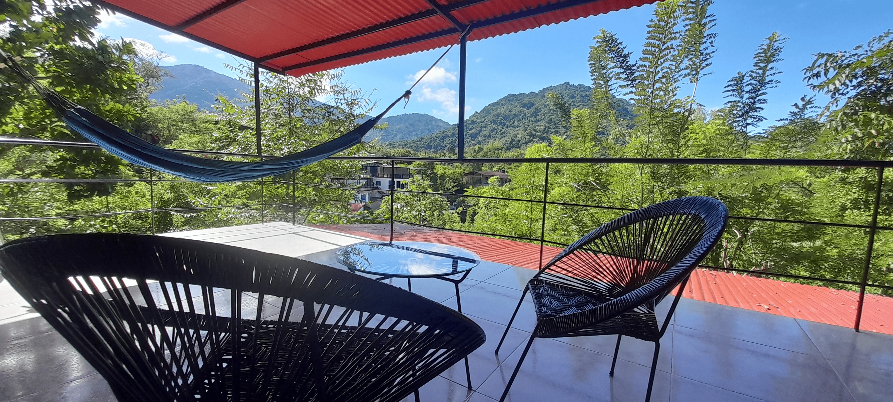 Shared rooftop terrace with hammock and mountain view